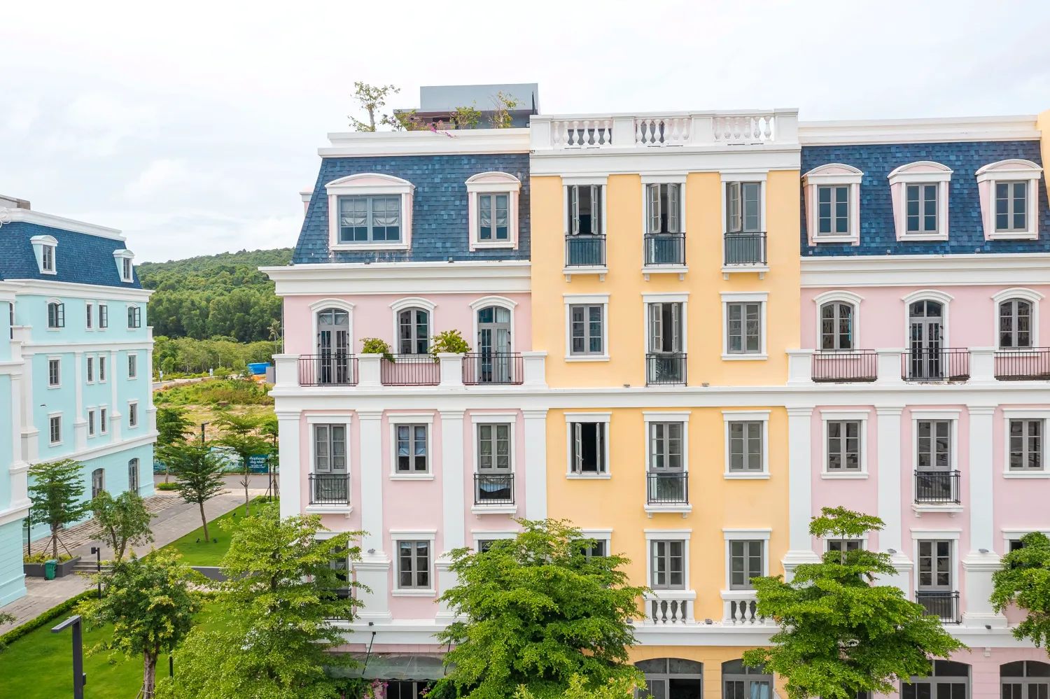 Pastel pink and yellow French-colonial mansard façade of Maison D’Rose Phú Quốc