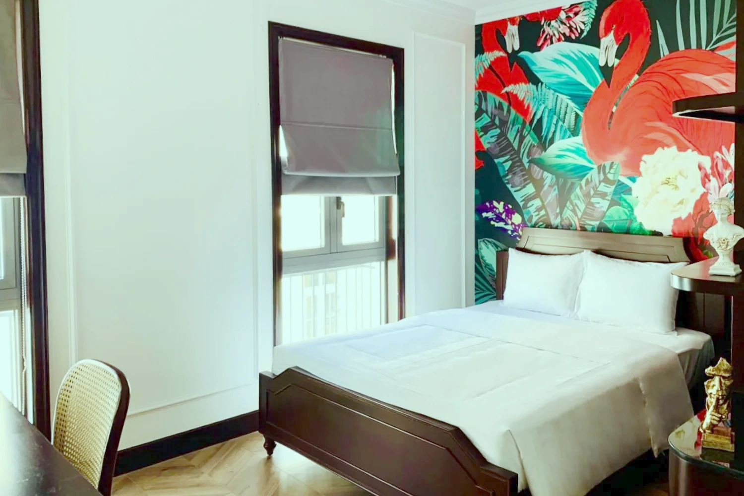 Family Room bedroom with a vivid hand-painted flamingo and tropical-foliage mural headboard above a dark-wood bed